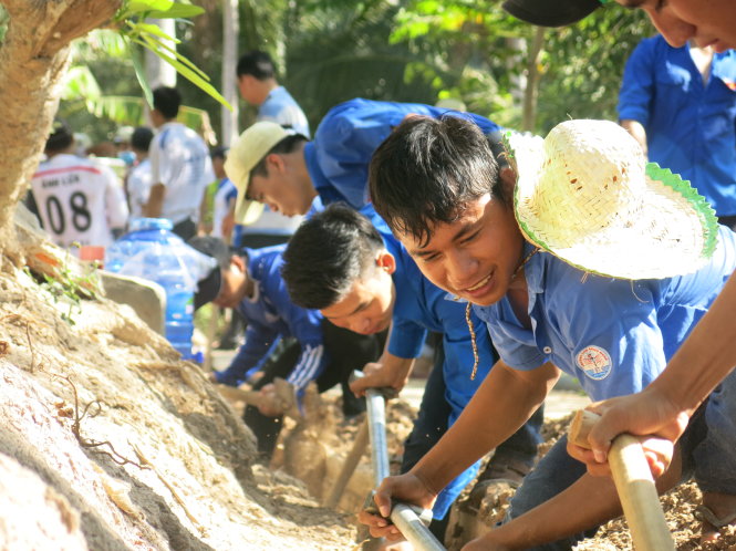 Thanh niên tình nguyện đào đường ống nước cho bà con nghèo giữa trưa mùa nắng nóng khắc nghiệt - Ảnh: T.Trang