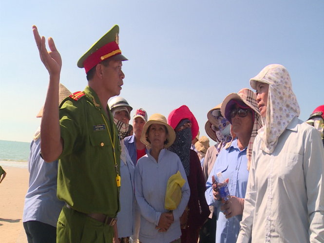 Công an vận động người dân thực hiện chủ trương cấm buôn bán, nấu nướng hải sản dưới bãi tắm - Ảnh: Quỳnh Giang.