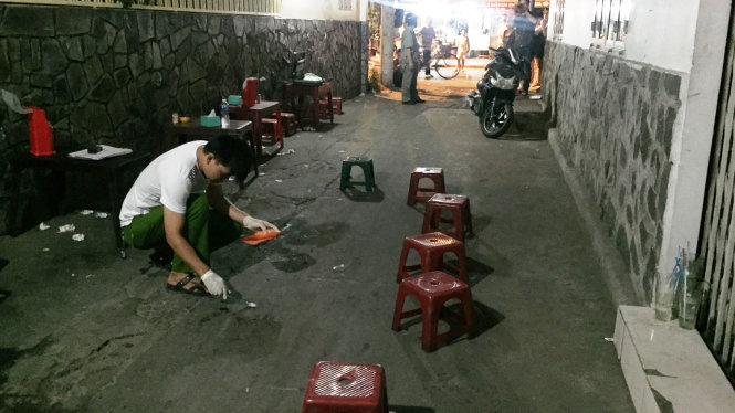 Lực lượng chức năng khám nghiệm hiện trường tại quán ăn vỉa hè trong hẻm 246 Hòa Hưng (P.13, Q.10) - Ảnh: Ngọc Khải