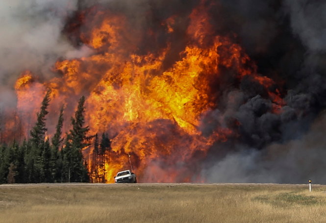 l Ảnh lớn: Lửa rừng dữ dội liếm vào một đường cao tốc gần Fort McMurray ngày 7-5 l Ảnh nhỏ (từ trái sang): Người dân sơ tán được tập trung trong một trại tạm trú thuộc tỉnh Alberta l Cảnh sát Canada đeo mặt nạ phòng khí độc trước khi tác nghiệp chống cháy rừng l Máy bay thả chất chống cháy ở Fort McMurray ngày 6-5 Ảnh: Reuters