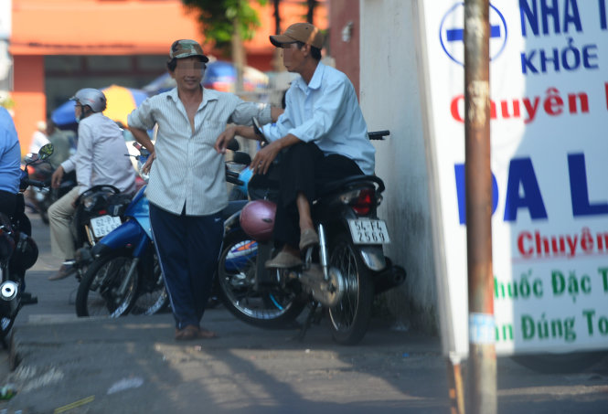 Hai “cò mồi” (đội nón lưỡi trai) luôn túc trực trước cổng Bệnh viện Da liễu (đường Nguyễn Thông, P.6, Q.3, TP.HCM) chờ đón người dân đi khám bệnh để chèo kéo vào các phòng khám tư nhân ăn hoa hồng
- Ảnh: Hữu Khoa