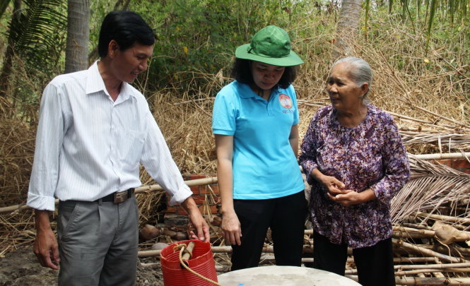 Bà Vũ Thị Mỹ Ngọc (áo xanh, giữa), Ủy viên thường vụ - Chủ tịch MTTQ Việt Nam quận 3 trao đổi về chất lượng nước giếng với người dân xã An Hiệp (H.Ba Tri, Bến Tre) - Ảnh: Lê Phan