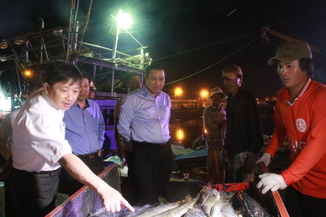 Ông Thơ cùng các cán bộ kiểm tra mẫu ở chợ đầu mối Hòa Cường - Ảnh: HỮU KHÁ