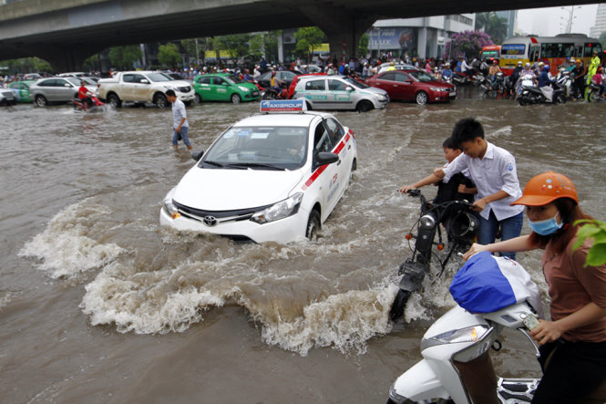 Ngập lớn tại ngã ba Phạm Hùng- Nguyễn Hoàng đã khiến nhiều phương tiện di chuyển khó khăn - Ảnh: NAM TRẦN