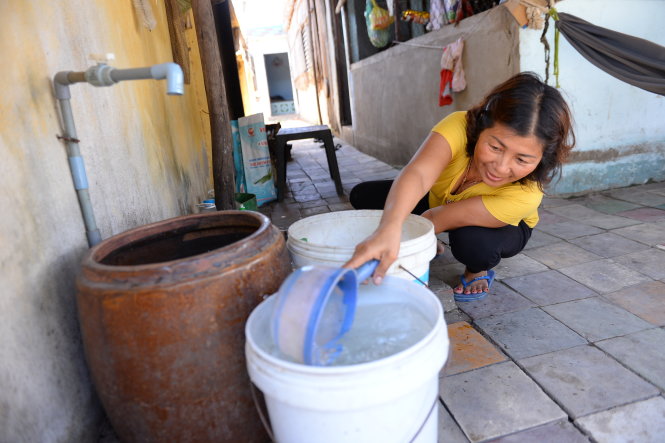 Bà Nguyễn Thị Loan (ấp Bình Thạnh, xã Bình Khánh, huyện Cần Giờ, TP.HCM) than thở bà phải mua lu, xô… trữ nước lại mới có sử dụng vì thường xuyên bị cúp nước - Ảnh: Hữu Khoa