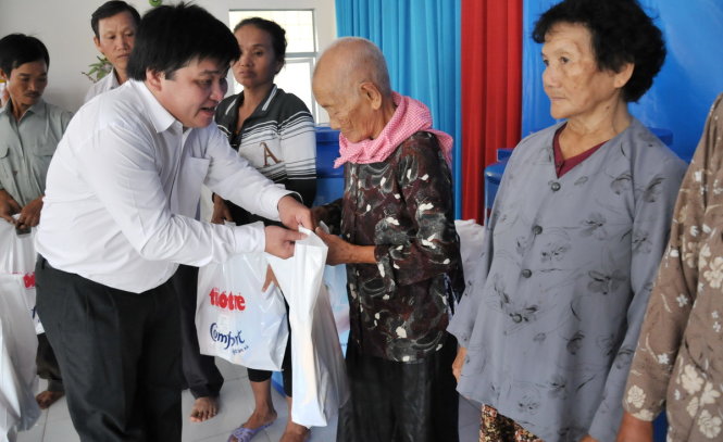 Ông Lê Thế Chữ - phó tổng biên tập báo Tuổi Trẻ trao quà cho bà con nghèo xã Thành Công, huyện Gò Công Tây - Ảnh: Thanh Tú