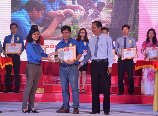 Chị Vương Thanh Liễu (trái), phó bí thư Thành đoàn TP.HCM, trao biểu trưng cho đại diện các tập thể được tuyên dương học tập và làm theo tấm gương đạo đức Hồ Chí Minh - Ảnh: Quang phương