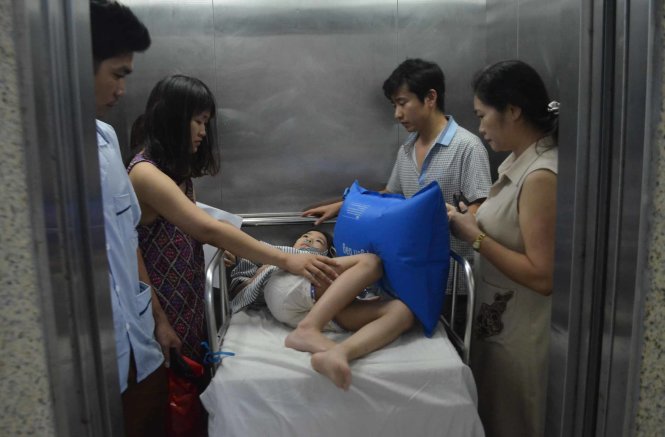 Em Nguyễn Lưu Bảo Hân (8 tuổi, trú Q.Long Biên, Hà Nội) đang được chuyển lên Khoa Hồi sức Bệnh viện Phụ sản - nhi Đà Nẵng - Ảnh: Tấn Lực