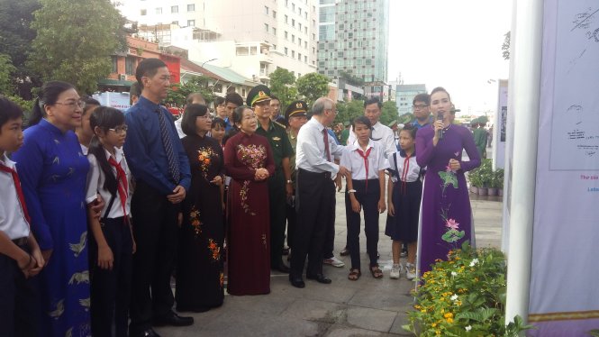 Lãnh đạo thành phố cùng đoàn viên thanh niên, các em học sinh xem triển lãm “TP.HCM - thành phố anh hùng” trên phố đi bộ Nguyễn Huệ - Ảnh: Ngọc Loan
