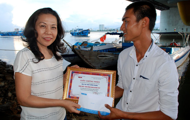 Đại diện báo Tuổi Trẻ (trái) trao giấy chứng nhận cùng tiền thưởng cho anh Mai Viết Dụng chiều 6-6 - Ảnh: VIỆT HÙNG
