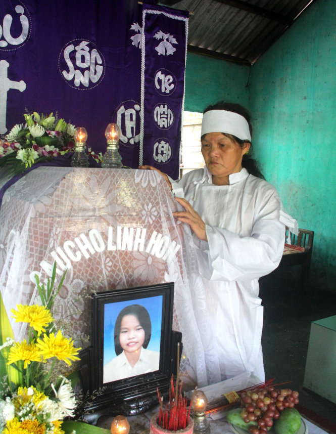 Bà Hương thẫn thờ đứng vuốt chiếc quan tài con gái - Ảnh: Nguyên Linh