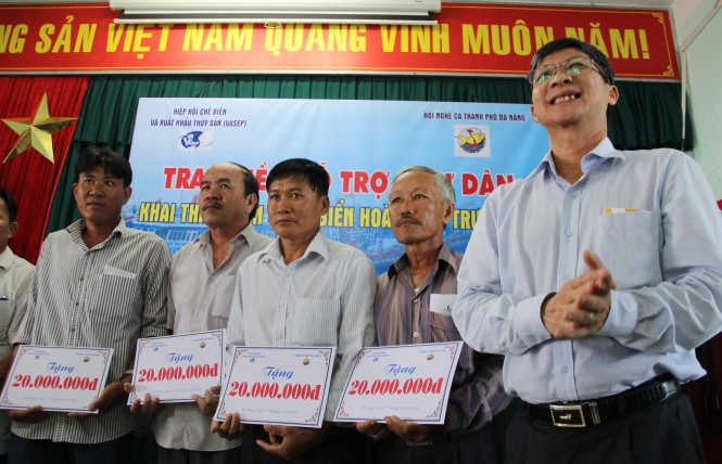 Ông Trương Đình Hòe, tổng thư ký VASEP, trao tiền hỗ trợ ngư dân miền Trung gặp nạn trên Biển Đông - Ảnh: Trường Trung