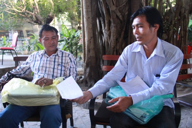 Hai ngư dân trình bày về hành trình gần hai năm làm thủ tục vay vốn theo nghị định 67 nhưng không được - Ảnh: Trần Mai