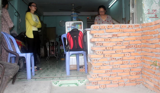 Đơn vị thi công xây bức tường chắn trước nhà dân trước khi triển khai công trình gây khó khăn việc đi lại - Ảnh: Q.KHẢI