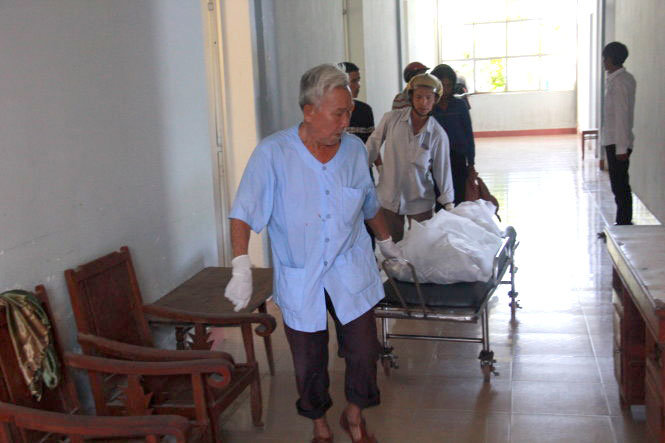 Ông Lên (trước) giao thi thể cho người thân đưa về nhà - Ảnh: Trần Mai