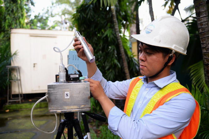Nhân viên Trung tâm Công nghệ và quản lý môi trường TP.HCM (ETM) lấy mẫu khí NO2 tại trạm quan trắc không khí đặt ở Trường THCS Hồng Bàng, Q.5 về phân tích nồng độ NO2 có trong không khí - Ảnh: HỮU KHOA