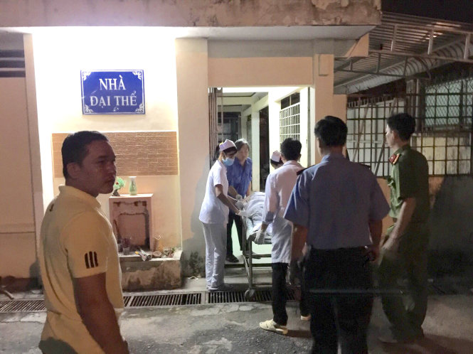 Cơ quan chức năng và các bác sĩ đang chuyển thi thể chị Hồng vào nhà đại thể để chuẩn bị cho công tác khám nghiệm - Ảnh: P.K