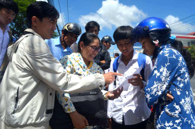 Ba thầy cô Trường THPT Tân Lược, Vĩnh Long phân tích đề thi cho học trò của mình - Ảnh: MINH TÂM