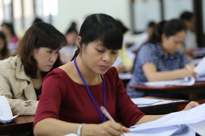 Cán bộ chấm thi đang chấm bài thi môn văn kỳ thi THPT quốc gia tại hội đồng chấm thi một trường ĐH ở TP.HCM chiều 5-7 - Ảnh: NHƯ HÙNG