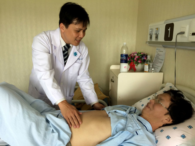 Bác sĩ Trần Công Duy Long khám cho ông H.T.T. bị ung thư gan sáng 6-7 - Ảnh: L.TH.H.