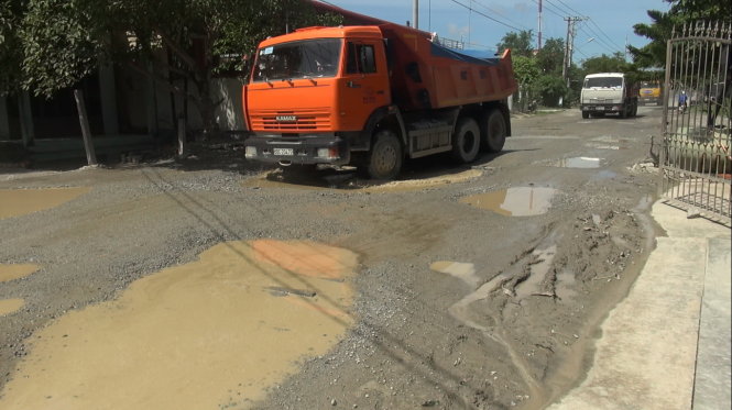 Xe ben chở đá chạy nườm nượp khiến đường vào di tích mộ Chị Sứ đầy ổ voi - Ảnh: N.TRIỀU