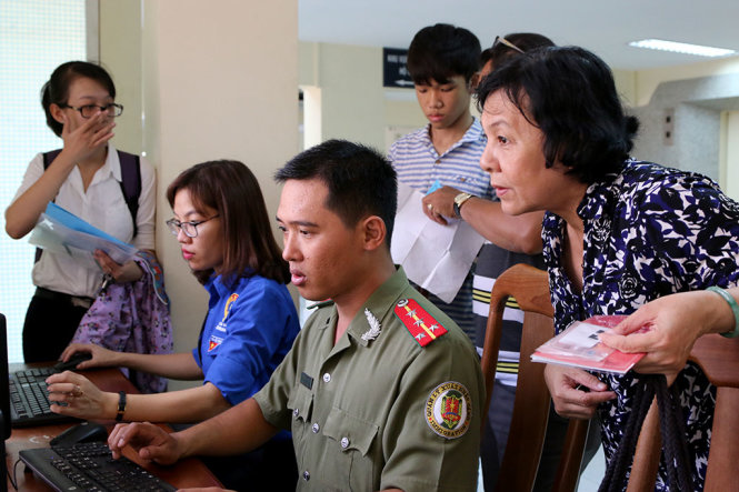 Công an TP.HCM làm tờ khai điện tử giúp người dân tại trụ sở Phòng quản lý xuất nhập cảnh (PA72) Công an TP.HCM (196 Nguyễn Thị Minh Khai, P.6, Q.3) - Ảnh: GIA MINH