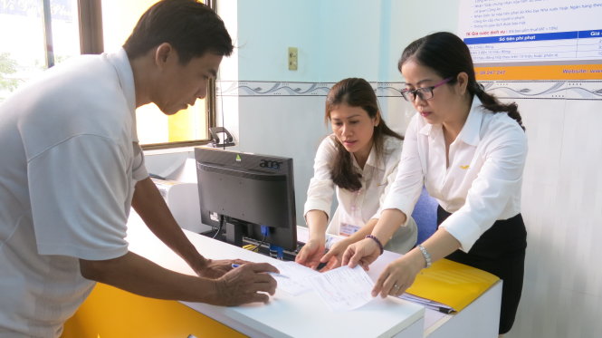 Người dân đóng tiền phạt qua quầy dịch vụ của bưu điện đặt tại Đội CSGT An Lạc (xã Tân Kiên, Bình Chánh) trong ngày đầu tiên triển khai - Ảnh: VŨ THỦY