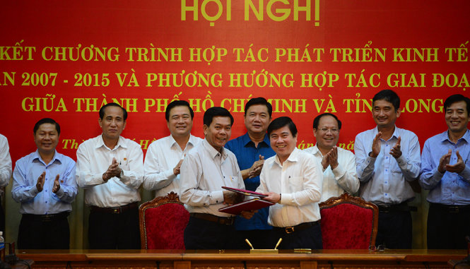 Chủ tịch UBND TP.HCM Nguyễn Thành Phong (phải) và chủ tịch UBND tỉnh Long An Trần Văn Cần ký kết tại hội nghị tổng kết chương trình hợp tác phát triển kinh tế - xã hội giai đoạn 2007-2015 và phương hướng hợp tác gia đoạn 2016-2020 giữa TP.HCM và tỉnh Long An sáng 16-7 - Ảnh: QUANG ĐỊNH