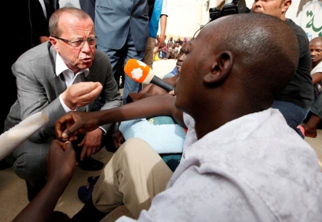 Đặc phái viên LHQ Martin Kobler đang nói chuyện với một trong những người nhập cư trái phép khi ông tới thăm trung tâm giam giữ người nhập cư trái phép Aby Saleem ở Tripoli - Ảnh: Reuters