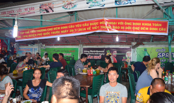 Băngrôn đòi gặp chủ tịch huyện treo trước các gian hàng tối 24-7 - Ảnh: H.TRUNG