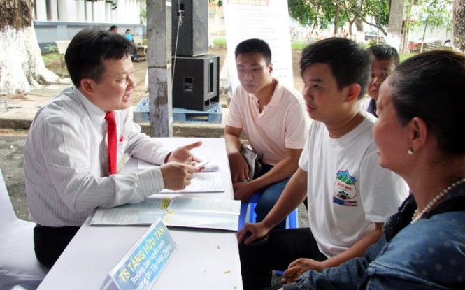 TS Tăng Hữu Tân, trưởng ban tuyển sinh Trường ĐH Tôn Đức Thắng, đang tư vấn cho thí sinh và phụ huynh trong Ngày hội tư vấn xét tuyển ĐH, CĐ năm 2016 - Ảnh: Trần Huỳnh