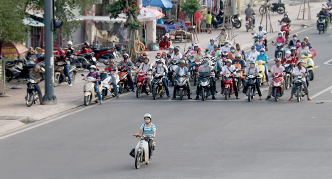 Một bạn nữ vượt đèn đỏ trên đại lộ Phạm Văn Đồng trong khi hàng chục người khác dừng lại Ảnh: Ngọc Hiển