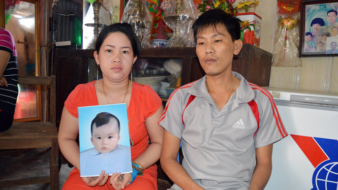 Vợ chồng anh Khánh thẫn thờ bên di ảnh con trai - Ảnh: H.TRUNG