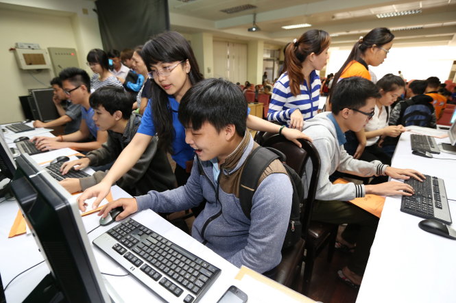 Sinh viên tình nguyện Trường ĐH Khoa học tự nhiên (ĐH Quốc gia TP.HCM) hướng dẫn thí sinh và phụ huynh đăng ký xét tuyển trực tuyến tại trường sáng 1-8 - Ảnh: NHƯ HÙNG
