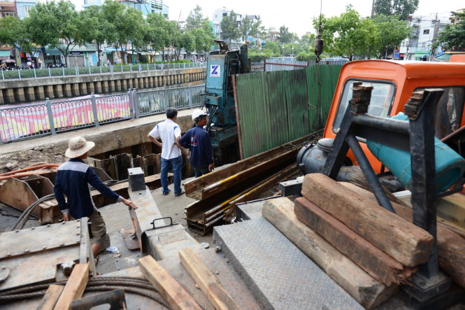Đơn vị thi công đóng cọc gia cố để phần miệng hố không bị mở rộng thêm - Ảnh: LÊ PHAN
