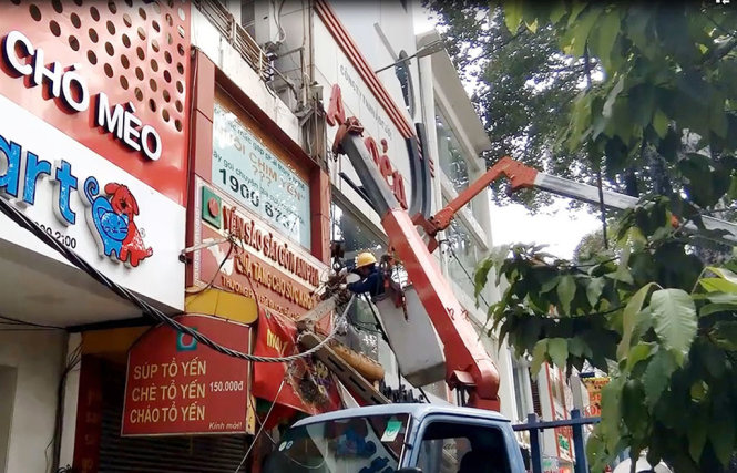 Các nhân viên công ty điện lực đang khắc phục sự cố - Ảnh: LÊ PHAN
