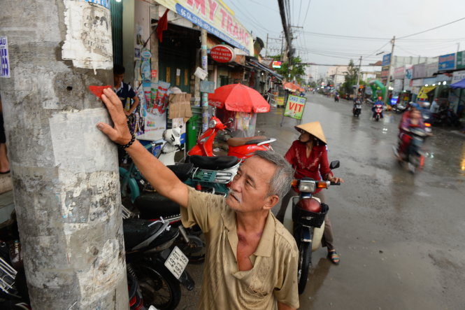 Ông Lê Văn Liền (KP3, P.Hiệp Bình Phước, Q.Thủ Đức, TP.HCM) chỉ tay vào dấu đỏ trên cột điện là mặt đường dự kiến nâng lên của quốc lộ 13 cũ. Theo ông Liền, nếu nâng đường như thế sẽ chắn hết cửa ra vào nhà ông và nhiều nhà người dân trong khu vực - Ảnh: HỮU KHOA