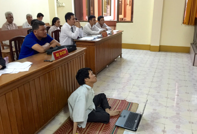 Bị tật do nhiễm chất độc da cam, Phạm Thanh Tùng không thể ngồi ghế, phải ngồi trên chiếu để hầu toà - Ảnh: N.TRIỀU