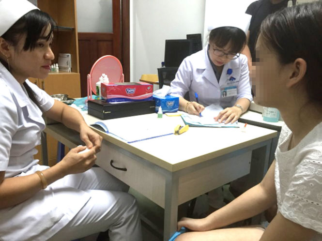 Nhân viên Bệnh viện Mắt TP.HCM tư vấn cho bệnh nhân về việc đeo kính áp tròng vào ban đêm để chỉnh độ cận - Ảnh: THÙY DƯƠNG