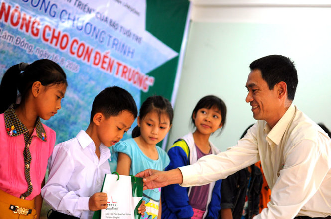 Đại diện công ty Cổ phần Greenfeed trao quà cho các em học sinh là con em các gia đình được vay vốn. Ảnh: LÂM THIÊN
