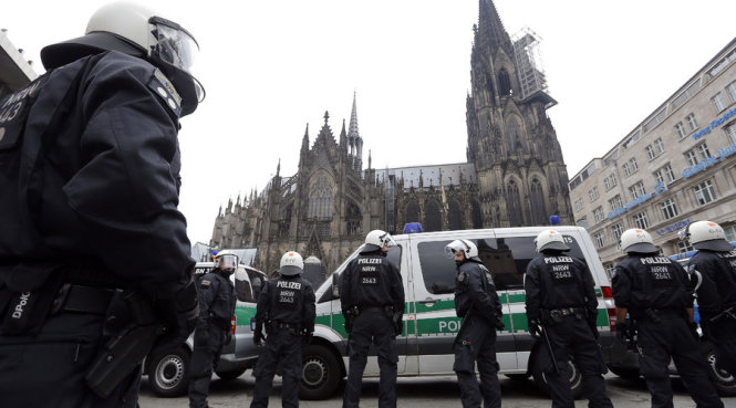 Cảnh sát chống bạo động Đức đang đứng trước nhà thờ Cologne ở Cologne, Đức - Ảnh: Reuters