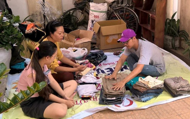 Các tình nguyện viên sắp xếp quần áo để người cần đến nhận - Ảnh: L.TRUNG