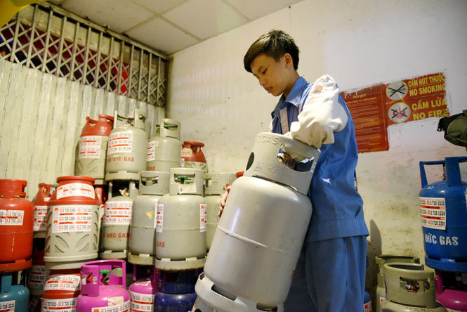Nhân viên một cửa hàng gas trên đường Nguyên Hồng, Q.Bình Thạnh, TP.HCM vận chuyển gas để giao hàng cho khách - Ảnh: HỮU THUẬN