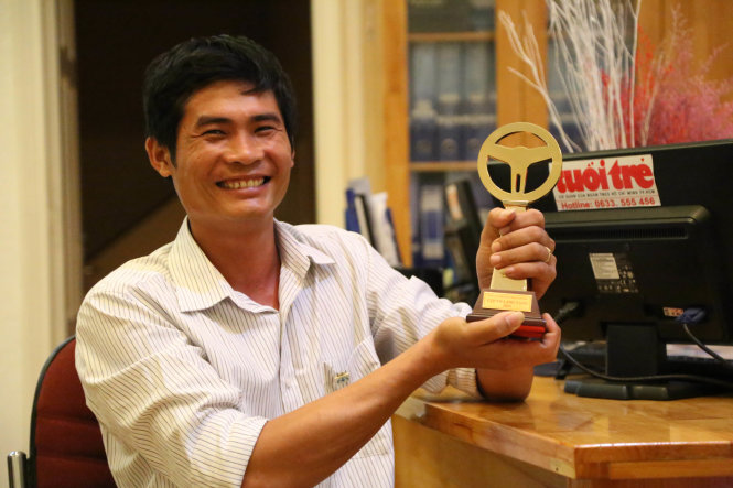 Tài xế Phan Văn Bắc và chiếc cúp Vôlăng vàng do Ủy ban An toàn giao thông quốc gia tặng - Ảnh: C.THÀNH
