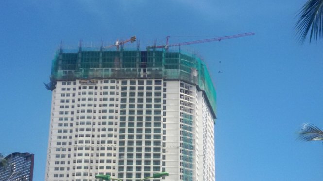 Cần cẩu đưa vật liệu lên để tiếp tục xây “vượt trần” - Ảnh: PHAN SÔNG NGÂN