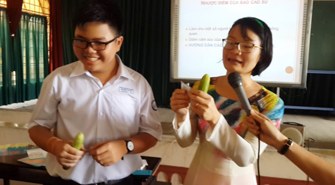 Cô hướng dẫn học trò thực hành dùng bao cao su trên quả dưa leo - Ảnh: M.D