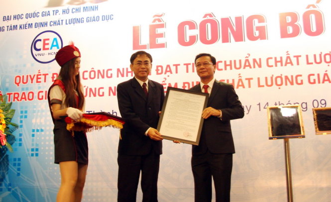 PGS.TS Nguyễn Hội Nghĩa trao quyết định quyết định công nhận và giấy chứng nhận đạt chuẩn chất lượng GDĐH do Trung tâm Kiểm định chất lượng giáo dục – ĐHQG TP.HCM cấp cho TS Nguyễn Thiên Tuế (phải) - Ảnh: TRẦN HUỲNH