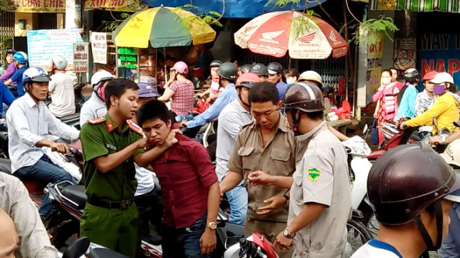 Cơ quan chức năng và người dân khống chế tên cướp - Ảnh: P.K