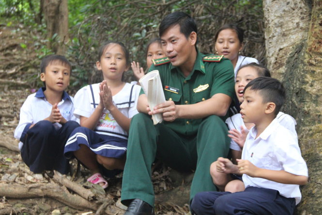 Thầy giáo bộ đội biên phòng Trần Bình Phục và các em học sinh là cư dân trên đảo Hòn Chuối - Ảnh: N.LOAN
