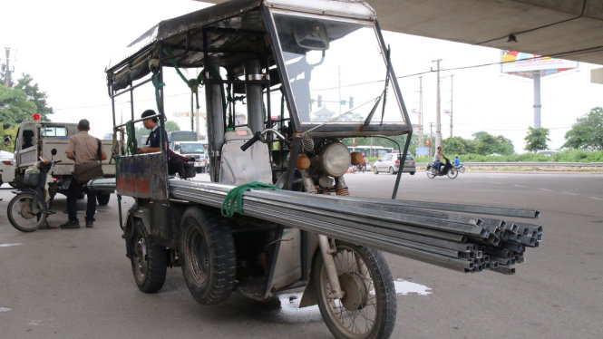 Một trường hợp xe ba gác chở vật liệu xây dựng quá khổ gấp 3 lần chiều dài xe rất nguy hiểm - Ảnh: HOÀI NAM